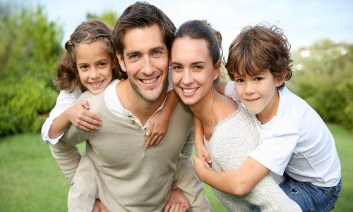 Parents giving piggyback ride to children